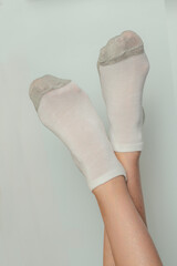 Female legs in socks on a gray background. Close-up.