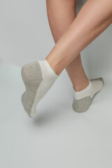 Female legs in socks on a gray background. Close-up.