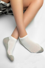 Female legs in socks on a gray background. Close-up.