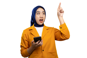 Excited Asian woman pointing up while holding smartphone isolated on transparent background