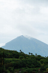Monte Agung nublado con silueta de palmeras, Bali