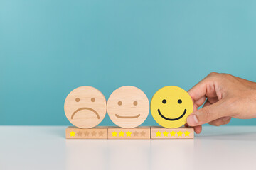 Satisfaction, service rating and positive feedback concept. A man choose wooden cube with smile...
