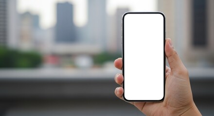 Hand holding phone with blank white screen; blurred city buildings background.