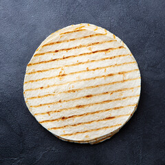Grilled tortillas, flat breads on dark grey background. Copy space. Top view.