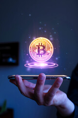 Mobile Phone Displays Glowing Bitcoin Coin in Mid-Air with Hand Shadow Dark Background