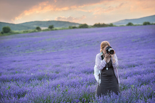 Mature woman standing in a lavender field taking a photo, Stara Zagora, Bulgaria