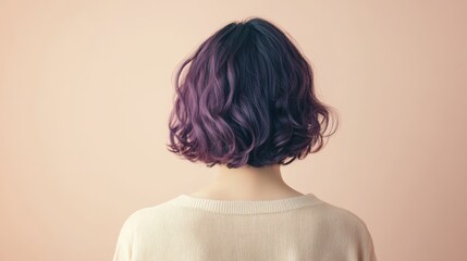 Female with short purple hair from back against beige background