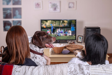 mother and daughter watching tv at home
