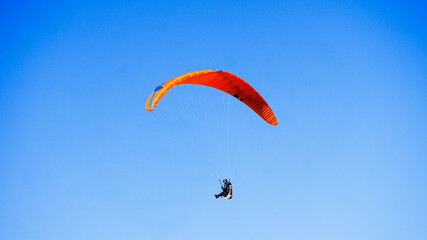 Solo Paraglider Flying Under Clear Blue Sky