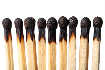 Burned matches in a row with varying degrees of damage on black background