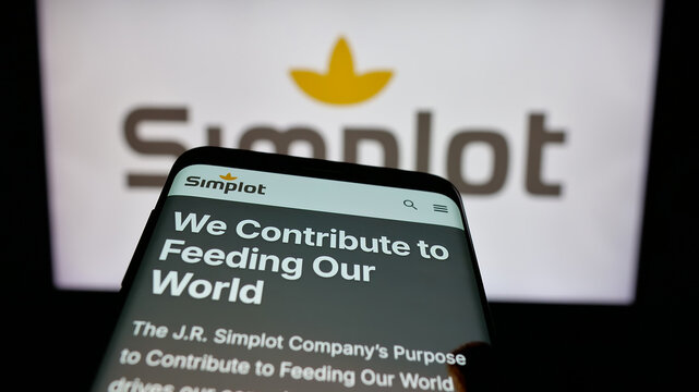 Stuttgart, Germany - 04-26-2025: Mobile phone with webpage of US agribusiness J. R. Simplot Company on screen in front of logo. Focus on top-left of phone display.