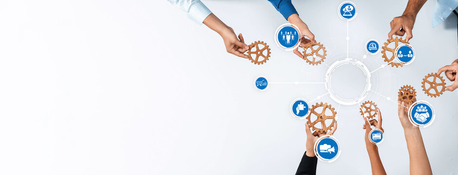 A dynamic overhead view of diverse hands engaging with gears, symbolizing teamwork and collaboration in business strategies for innovation and growth. Amity