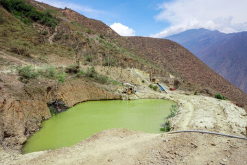 Toxic waste water pond from gold mining operation in the mountains of Peru, highlighting environmental impact in a remote Andean landscape.