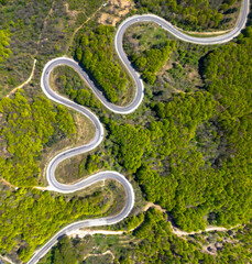 A beautiful winding road intertwined with nature. Aerial view of the winding road lined with lush green trees between domaniç district of kütahya and bursa inegöl.