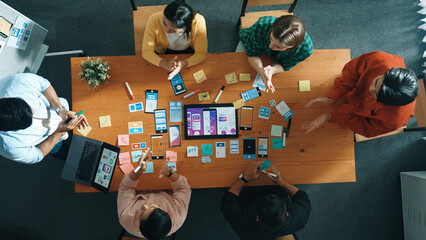Top down view of business team writing idea on sticky note while planing for Ux Ui design for...