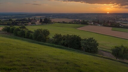 A large field with a level lawn stretching out over the horizon at sunset.