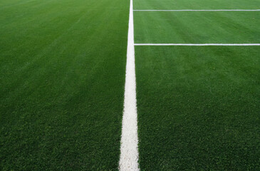 Obraz premium close-up view the green grass of a sports field, associated with athletic activities and outdoor recreation.