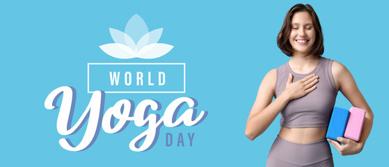Thankful young woman with yoga blocks pressing hand to chest and smiling on blue background