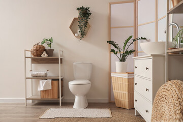 Interior of light bathroom with sink, toilet bowl and folding screen