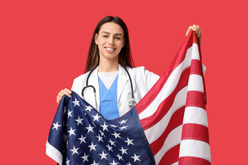 Young female doctor with USA flag on red background