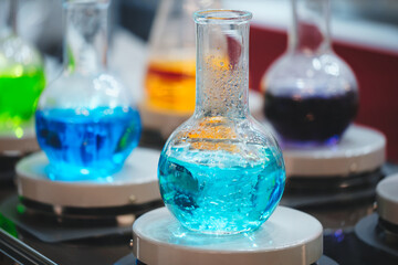 Collection of colorful liquids in glass vials in a laboratory including blue, green and purple. Curiosity and scientific exploration concept
