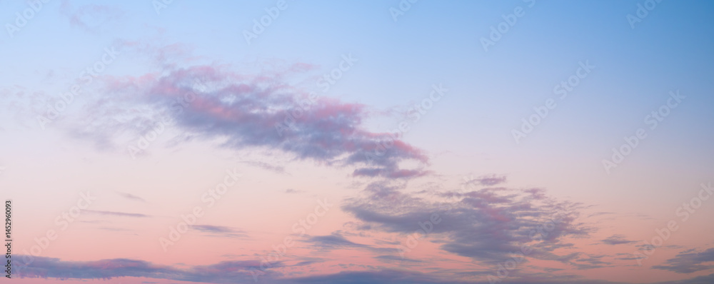 Poster a beautiful blue sky with a few clouds and a pinkish hue. sky is calm and peaceful, and the clouds a