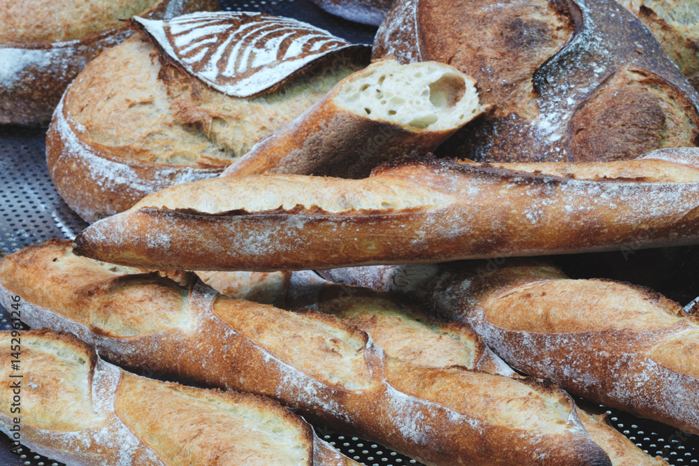 Aufkleber a bunch of bread loaves with one of them cut open. the bread is white and has a crust.