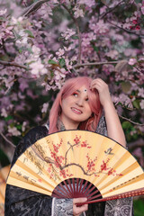 Girl in anime kimono next to pink apple tree