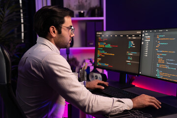 Working smart IT developer analyzing data software development on two pc screen, creating...