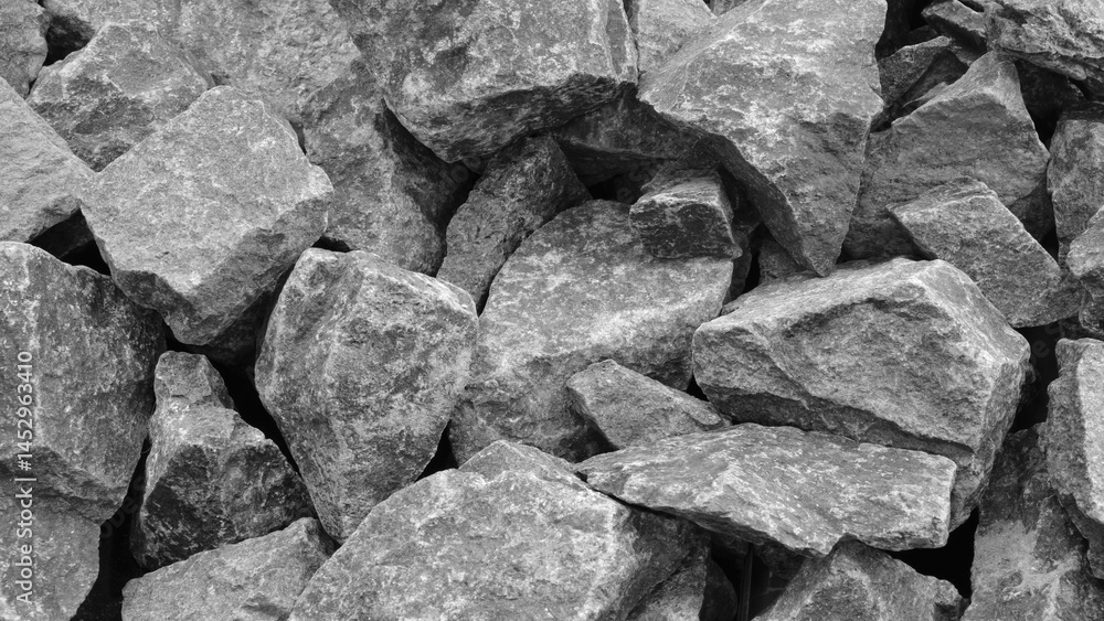 Poster A pile of gray rocks with a rough texture. The rocks are piled up in a way that they form a wall. image has a rugged and natural feel to it, with the rocks appearing to be weathered and worn.