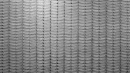 A grey and white woven fabric with a striped pattern. stripes are of varying sizes and arranged in such a way as to create a sense of depth and texture. background is lit from above