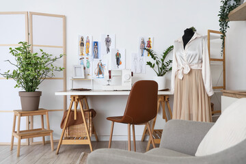 Interior of atelier with tailor's workplace, drawings and mannequin