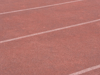 artificial turf of a sports stadium in red, textured background without people