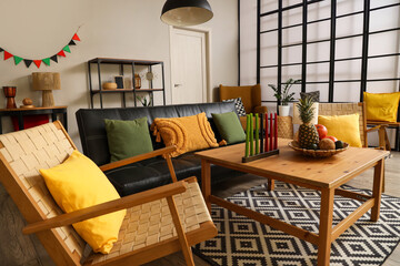 Interior of living room decorated for Kwanzaa celebration with sofa, armchairs and table