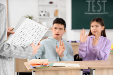 Female teacher with bad results of school test in classroom, closeup