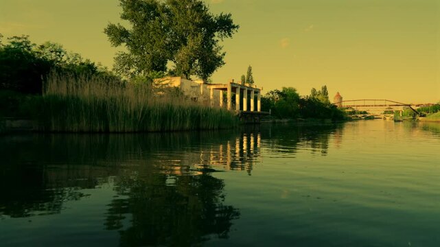 boat ride on the Bega River in Timisoara with reflections of the sky in the water, buildings and bridges along the river, 4k