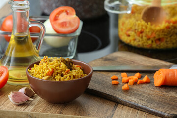 Bowl of tasty pilaf on table in kitchen, closeup