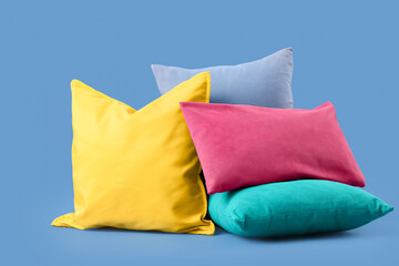 Different colorful pillows on blue background