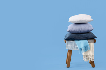 Stool with different pillows on blue background