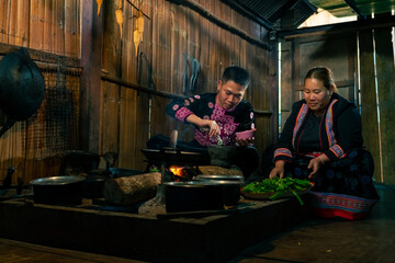 Asian family cooking and having dinner together at home. Hill tribe man and woman in traditional...