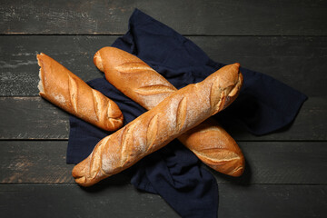 Fresh baguettes on black wooden background