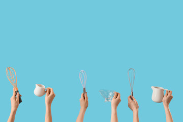 Female hands with whisks and gravy boats on blue background