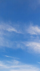 Blue sky with white soft cloud background. Vertical real natural texture. Calm Summer blue skies cloud gradient