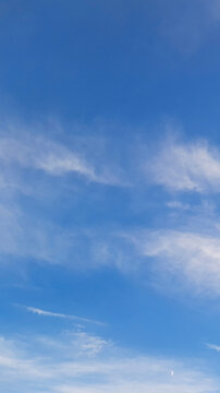Blue sky with white soft cloud background. Vertical real natural texture. Calm Summer blue skies cloud gradient