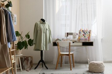 Tailor's workplace and mannequin near window in atelier interior