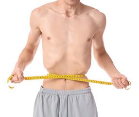 Young man with anorexia measuring his waist on white background