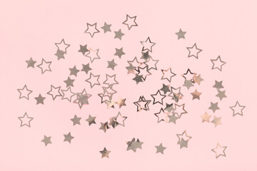 Beautiful silver confetti in shape of star on pink background