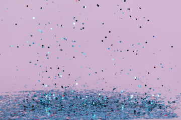 Flying blue confetti on lilac background