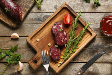 Composition with tasty blood sausage on wooden background, top view
