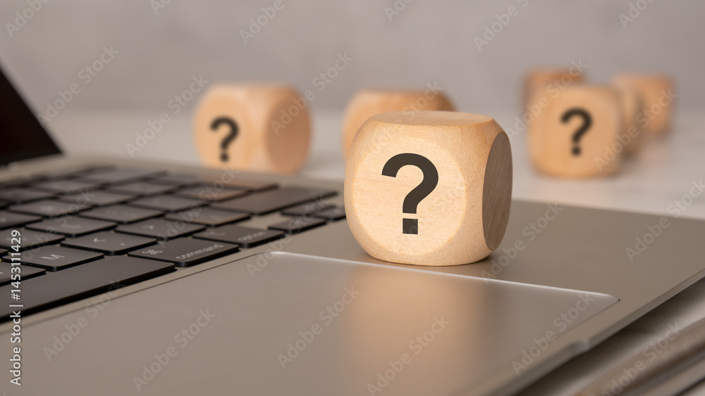 Poster wooden cube with question mark on laptop keyboard, close-up concept image